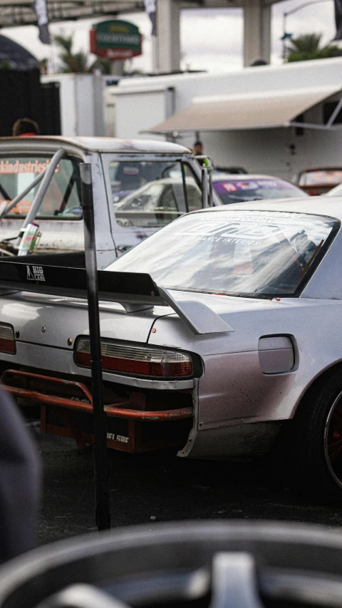 a grey car parked in front of other cars