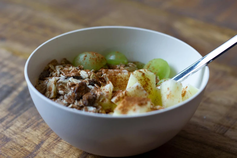 a bowl of food with cereal, nuts and fruit in it