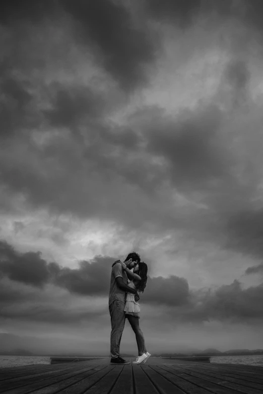a man and woman kissing on the pier