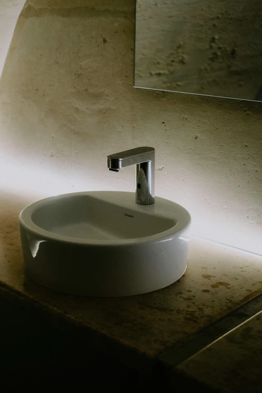 a bathroom sink sitting under a mirror in a room