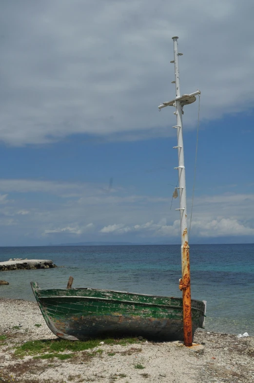 a boat sitting on the shore near the ocean