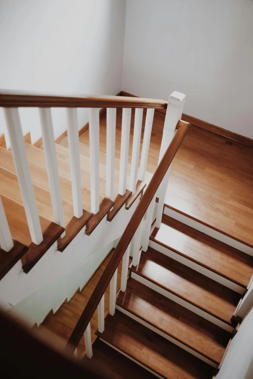 white wooden stairs next to a wall in a house