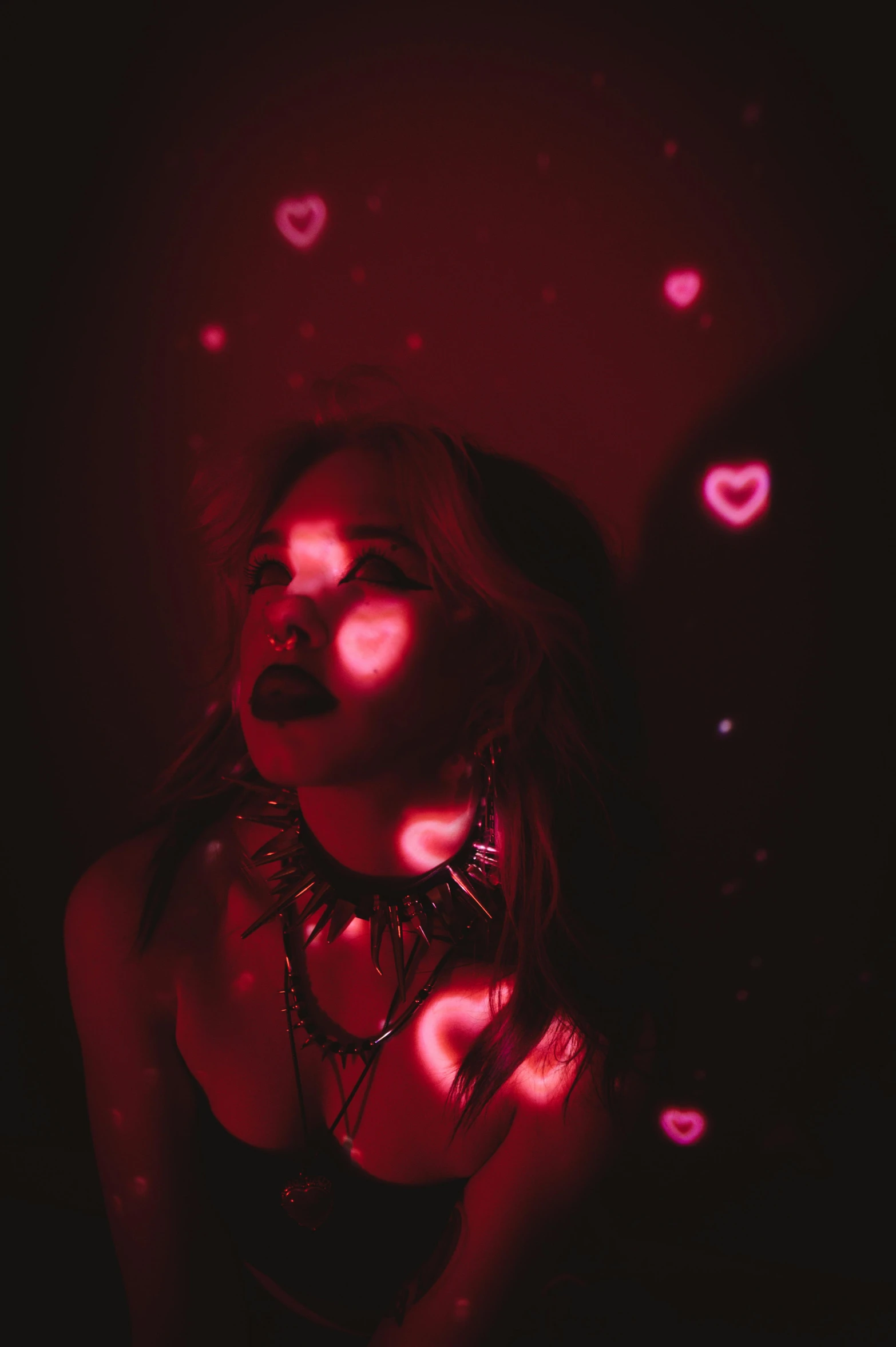 a girl in a dark po with hearts coming out of her 