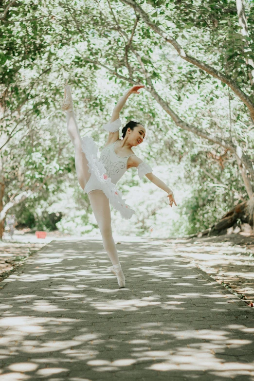 a ballerina in white is dancing on a path