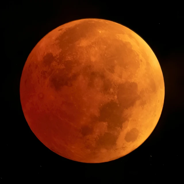 the big orange moon is in the dark sky