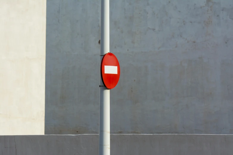 a pole with a red sign is on the road