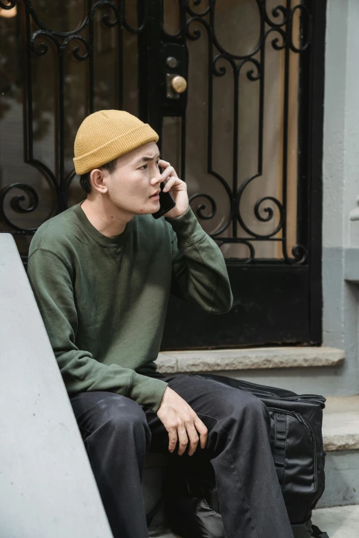 a man sitting on steps while talking on a cell phone