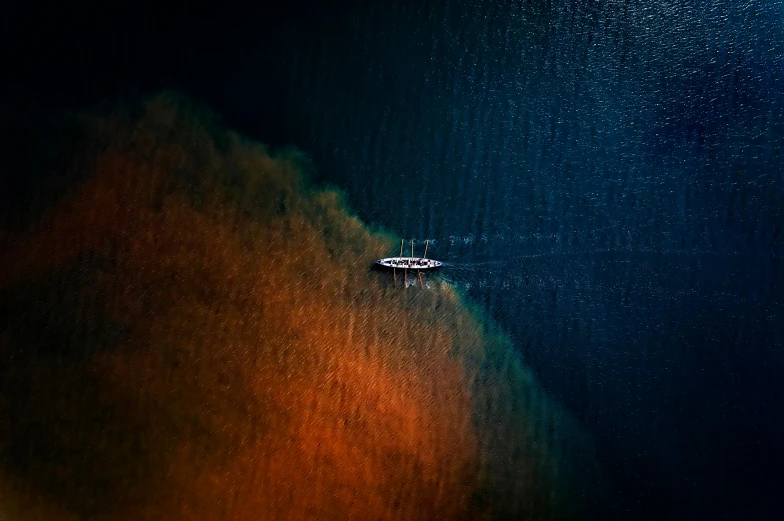 a small boat floats in the distance under stars