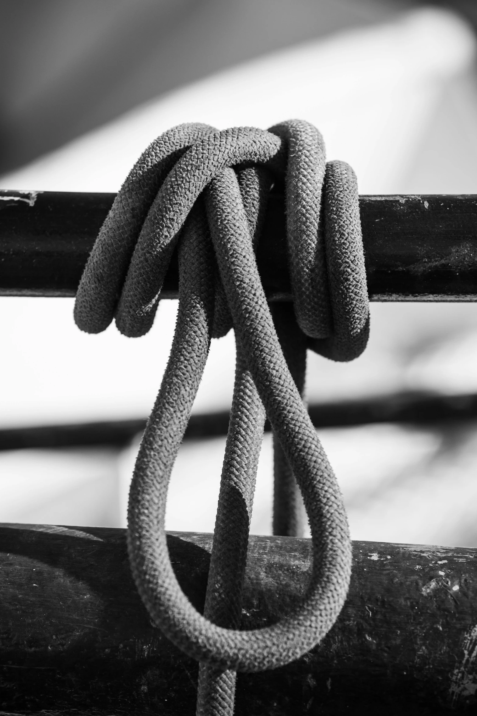 black and white pograph of a knot tied to a wooden beam