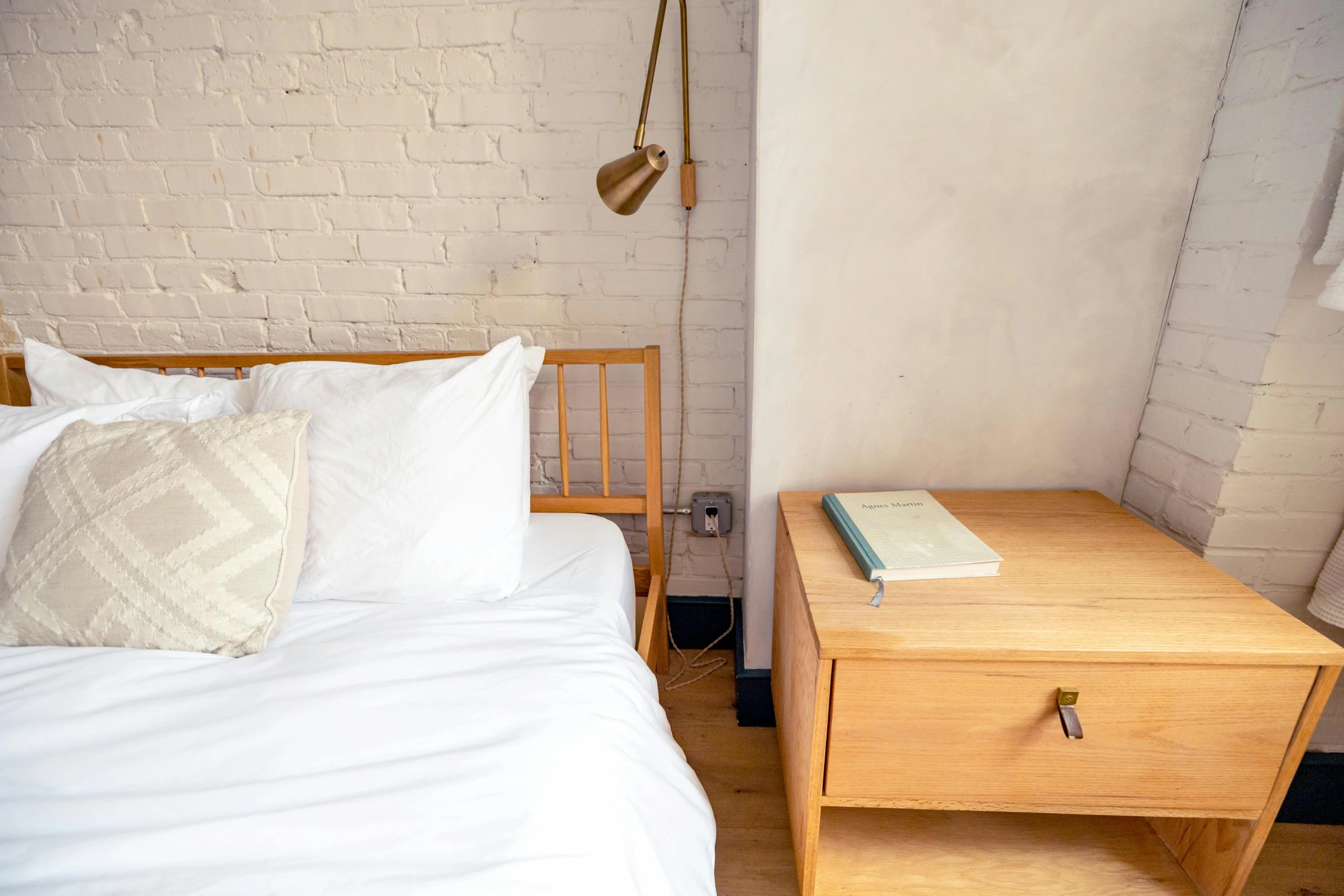 a bed with two pillows and a lamp on top