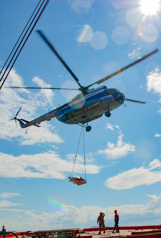 a helicopter that is lifting soing out to the sky