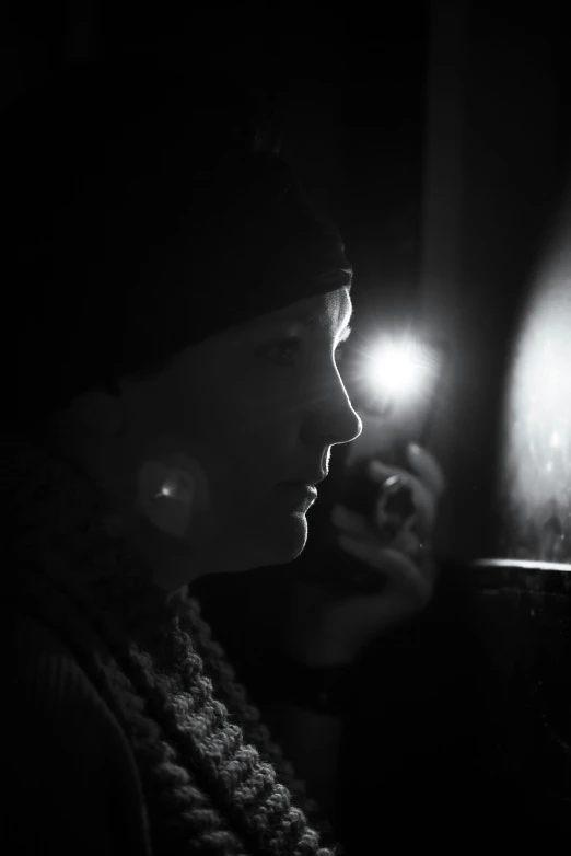 a woman standing with a flashlight at night