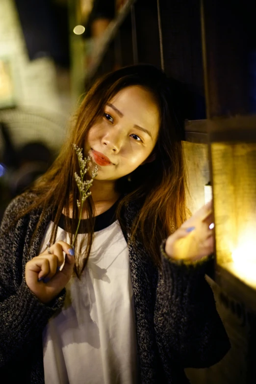 woman holding flower in her right hand and posing for the camera