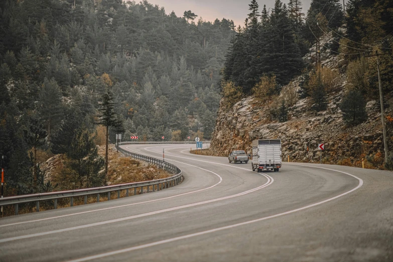 two semi trucks driving on a curved road