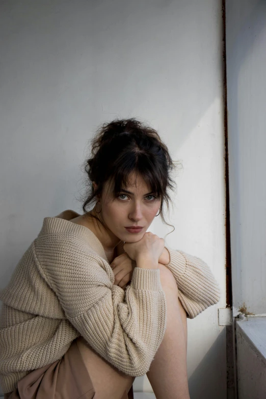 a young woman in tight clothing sits on the ground