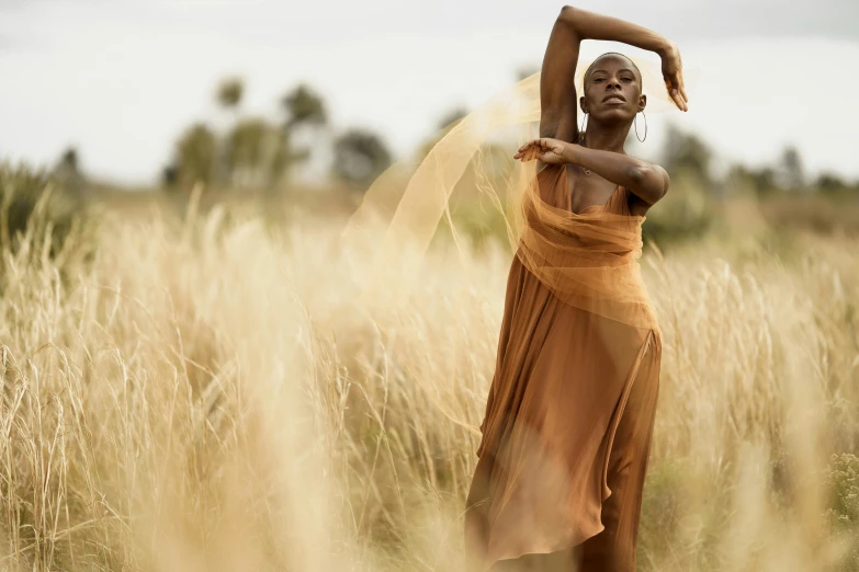 a woman in the middle of a field holding her arm up