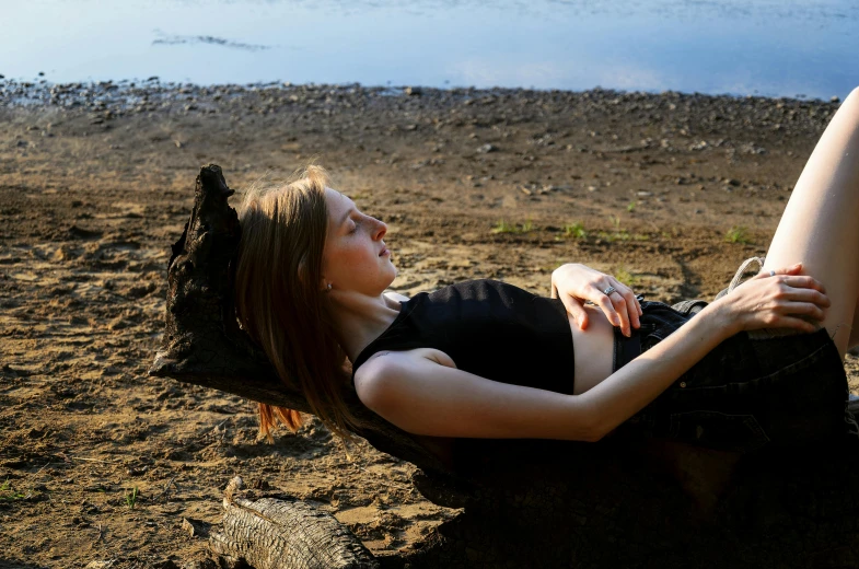 a young woman sitting on top of a sandy beach