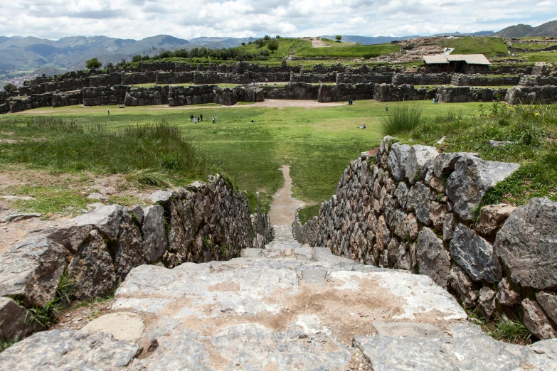 a rocky path leading towards an open field