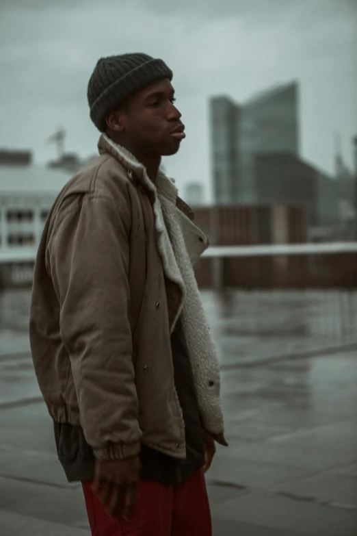 a black man wearing a scarf standing in the rain