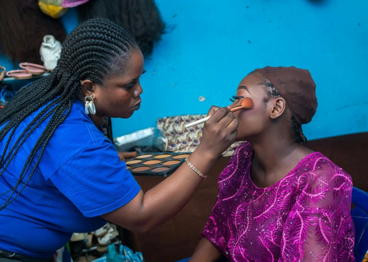 a woman helping another women brush her teeth