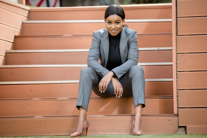 a woman sitting on the steps of an orange building