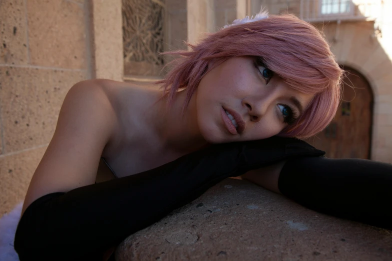 a girl with pink hair posing on the side of a building