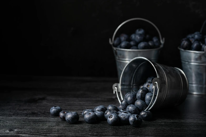 a bucket filled with berries sitting on top of a table