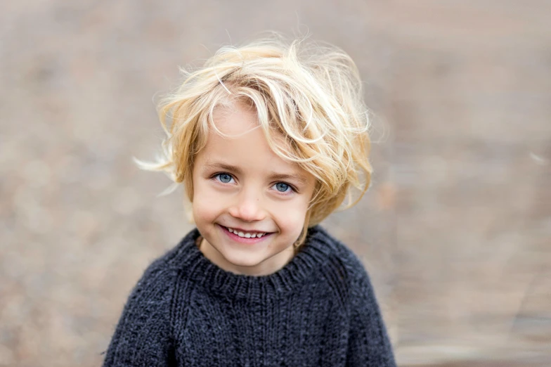 a boy that is smiling with his hair