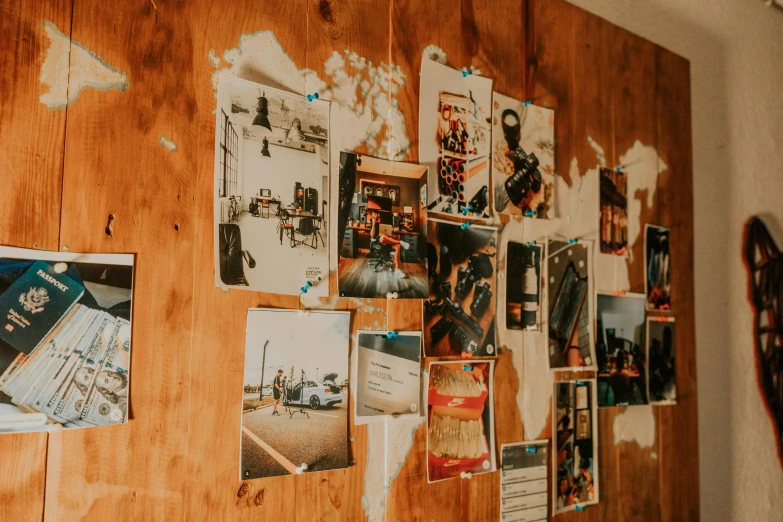a wall with many pictures and papers on it