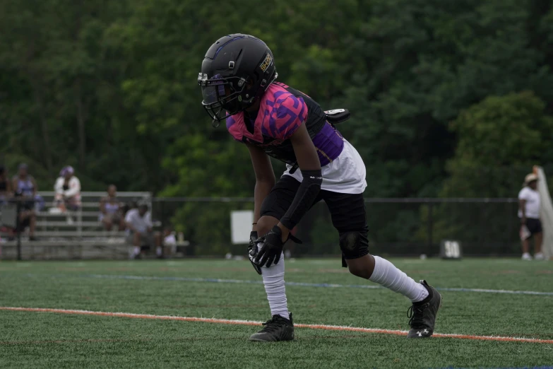 a football player waits on the field for the ball to be thrown