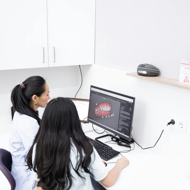 a couple of women sitting at a computer