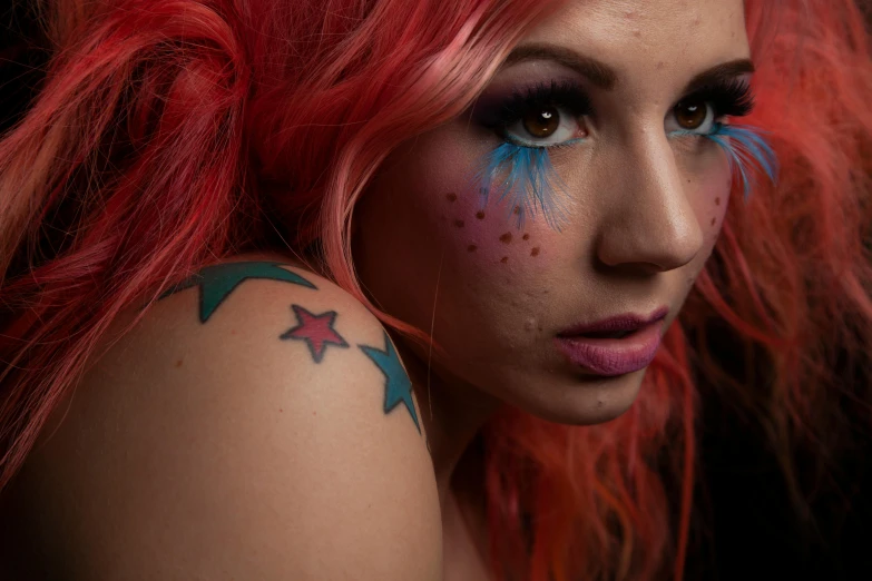 a woman with red hair has makeup on and has stars painted on her body