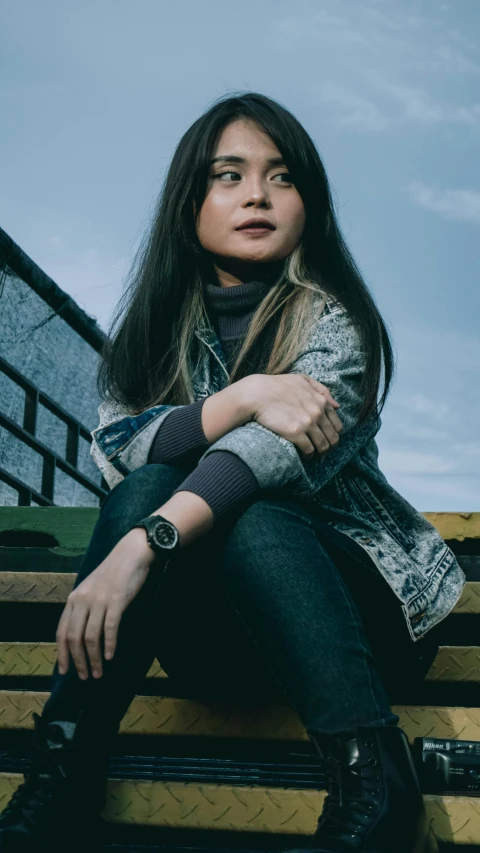 a young woman sitting on the stairs, posing for the camera