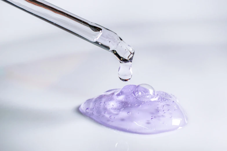 a purple liquid being extracted into a flask