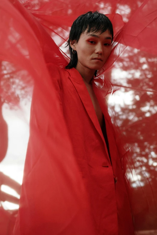 a woman in red standing under some shade