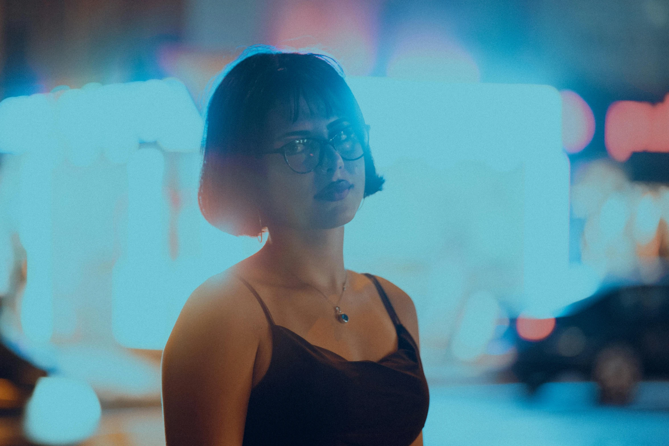 a woman stands on the side of a city street