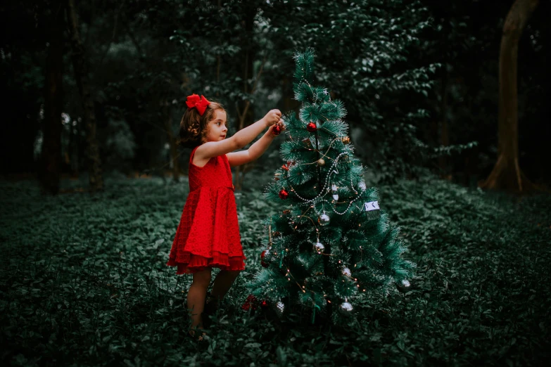 a little girl is looking at the christmas tree