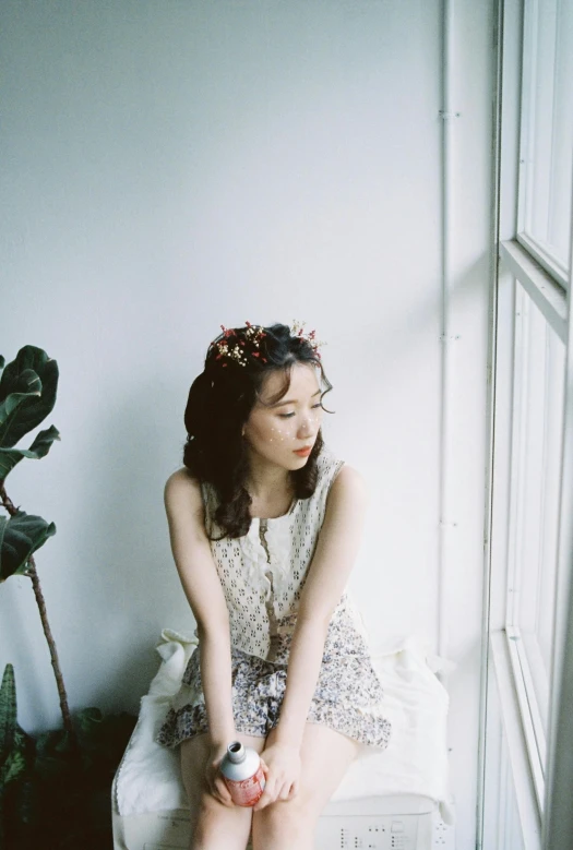 girl sitting on a bed with an object in her hand