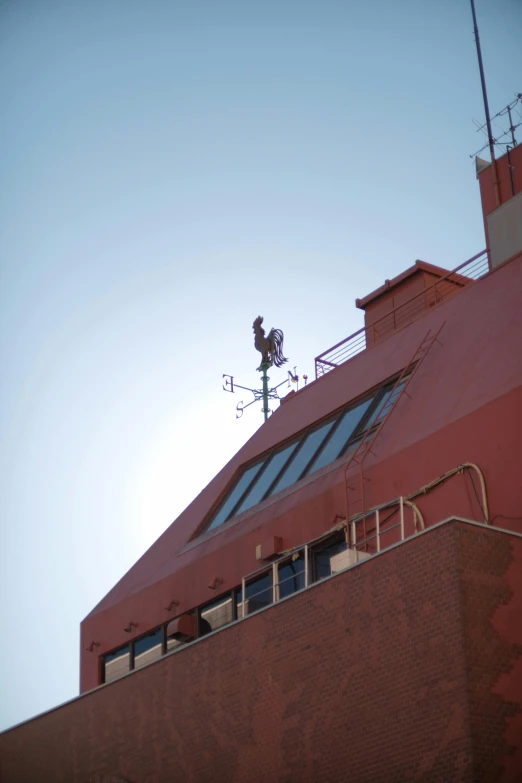 the top of a building with a metal weather vane on it's side