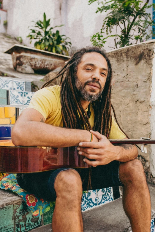 the man has dreadlocks sitting on a bench