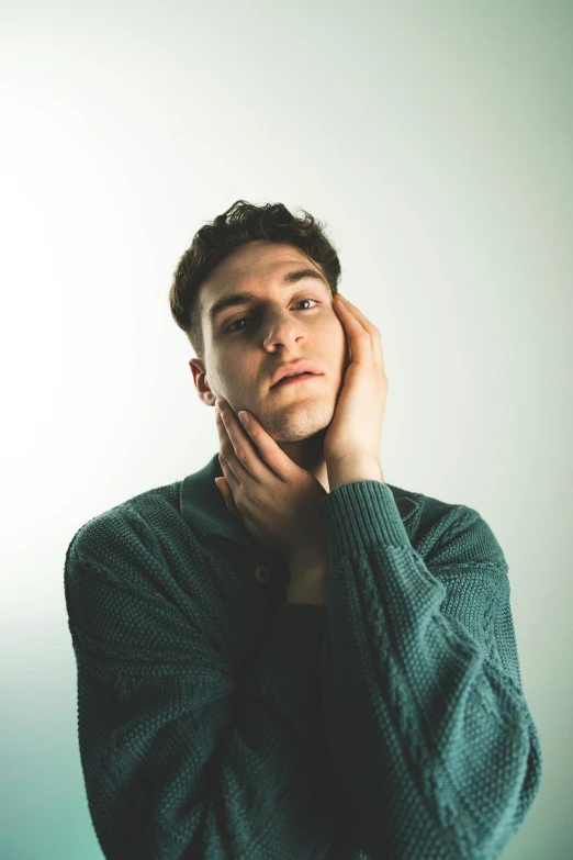 a man is looking into the camera while holding his hand up to his face