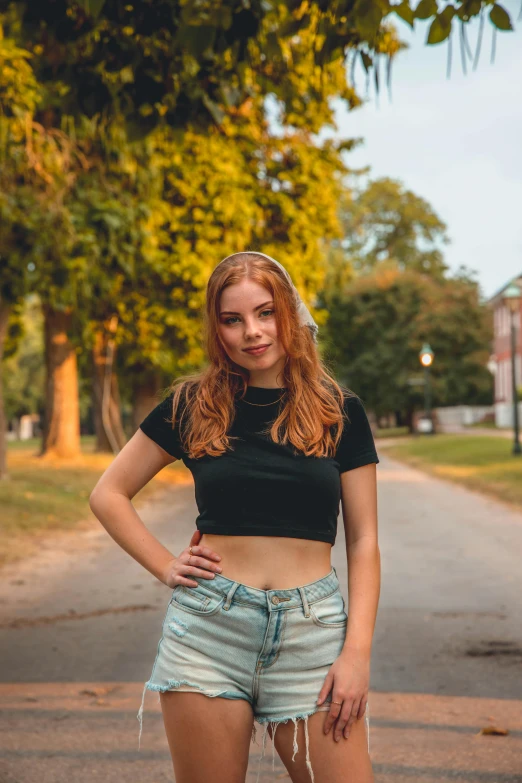 a girl is standing next to the road