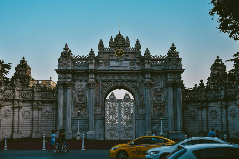 a yellow car in front of an ornate archway