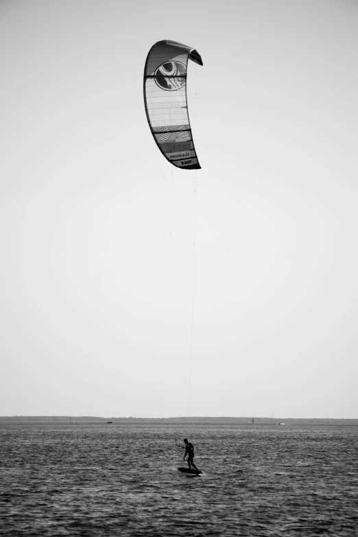 person holding onto a kite as they surf in a body of water