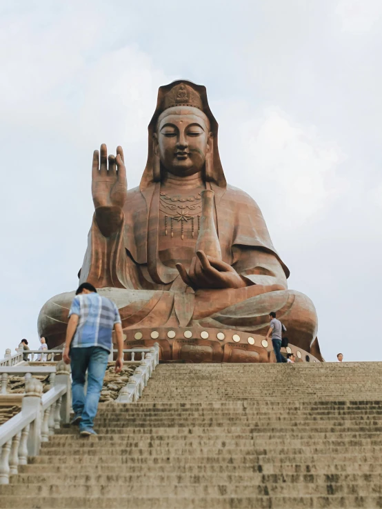 a giant buddha statue is pictured on top of stairs