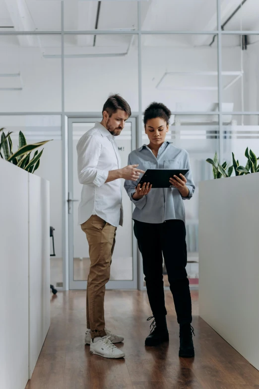 an office man and woman looking at soing on a tablet