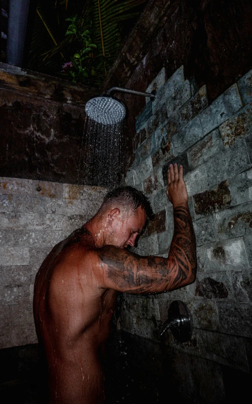 a man that is standing under a shower