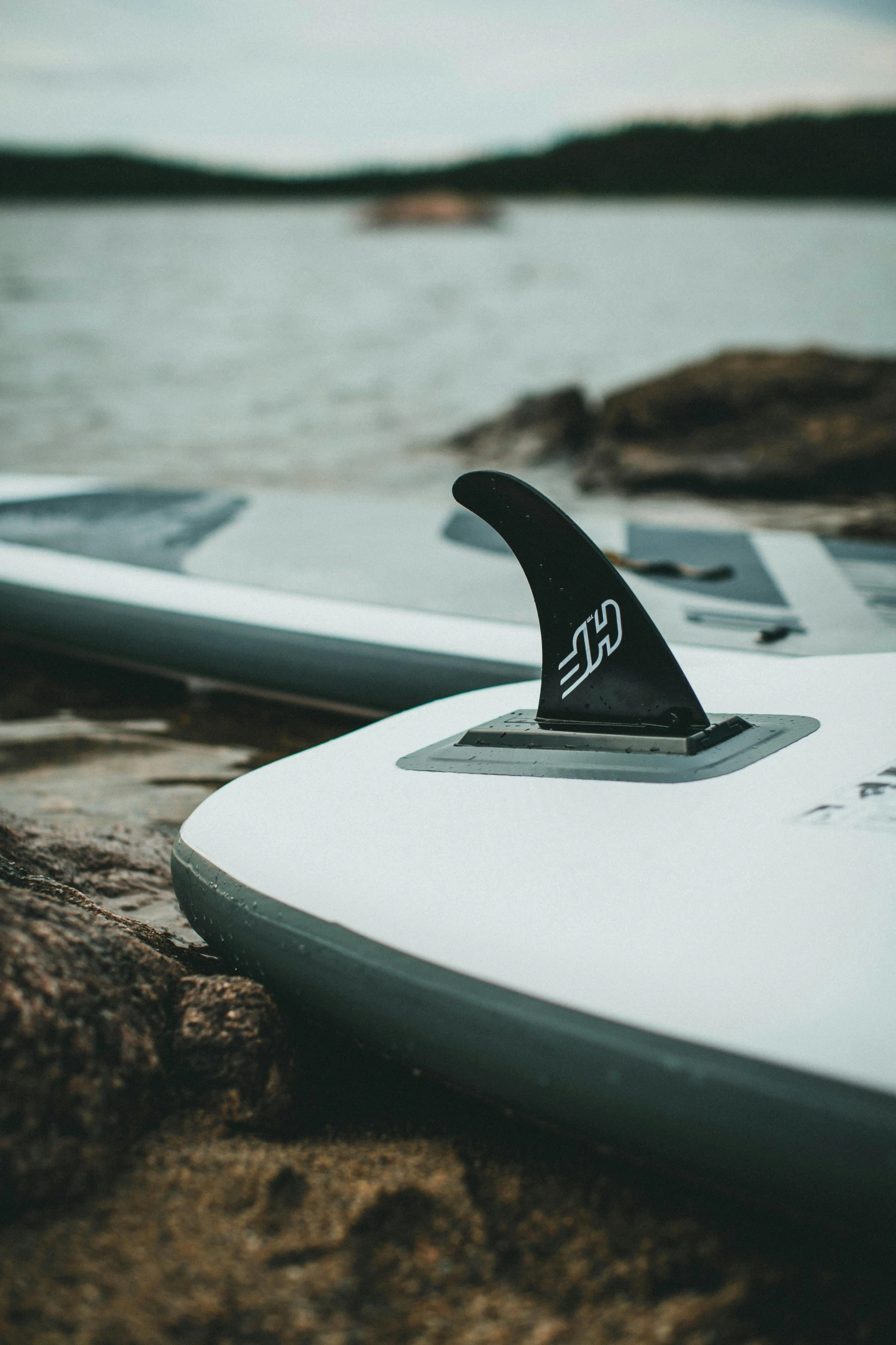 two surfboards and one is laying on the beach