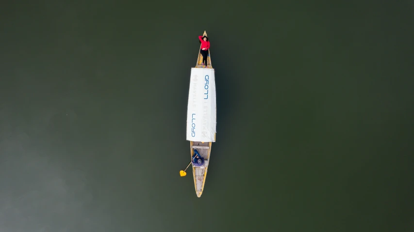 a small white boat on water with a person standing on top