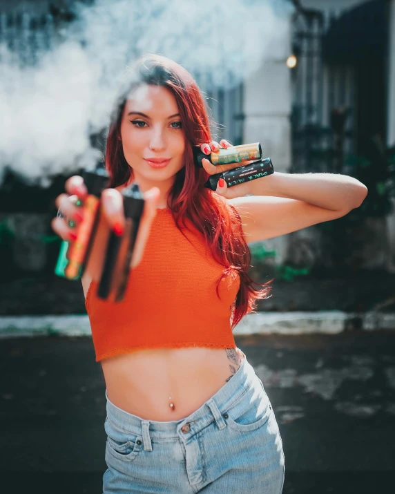 a woman holding two handguns while standing on the street